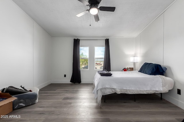 bedroom with baseboards, ceiling fan, a textured ceiling, and wood finished floors