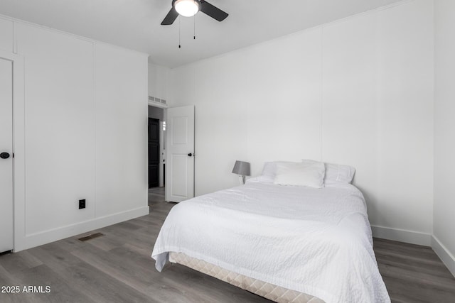 bedroom with baseboards, wood finished floors, and visible vents