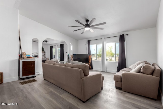 living area with wine cooler, plenty of natural light, a ceiling fan, and wood finished floors