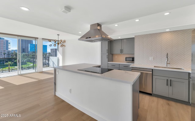 kitchen with decorative backsplash, sink, island range hood, stainless steel dishwasher, and black electric cooktop