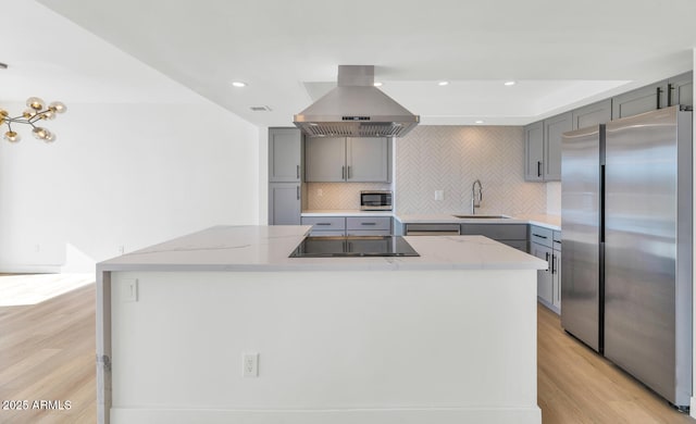 kitchen with island exhaust hood, stainless steel appliances, backsplash, a kitchen island, and sink