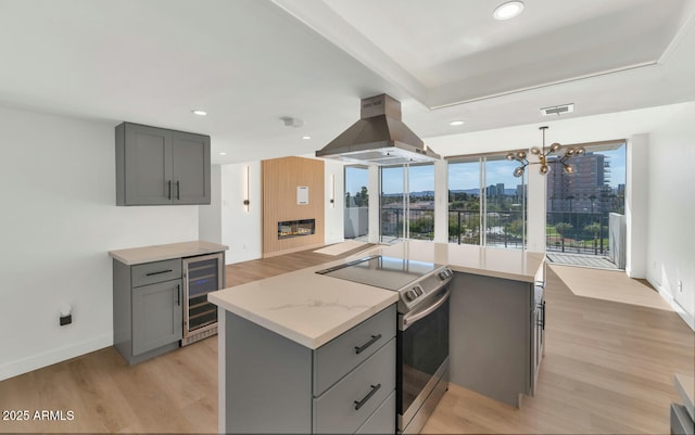 kitchen with wine cooler, island exhaust hood, gray cabinets, and stainless steel range with electric cooktop