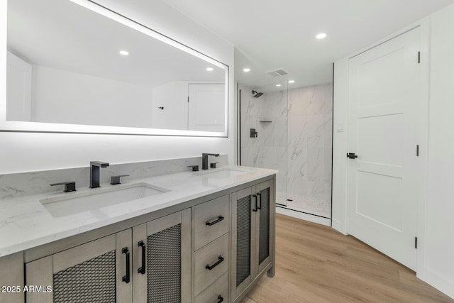 bathroom featuring vanity, a tile shower, and hardwood / wood-style flooring