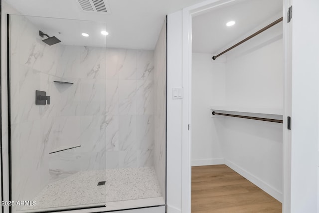 bathroom featuring wood-type flooring and tiled shower