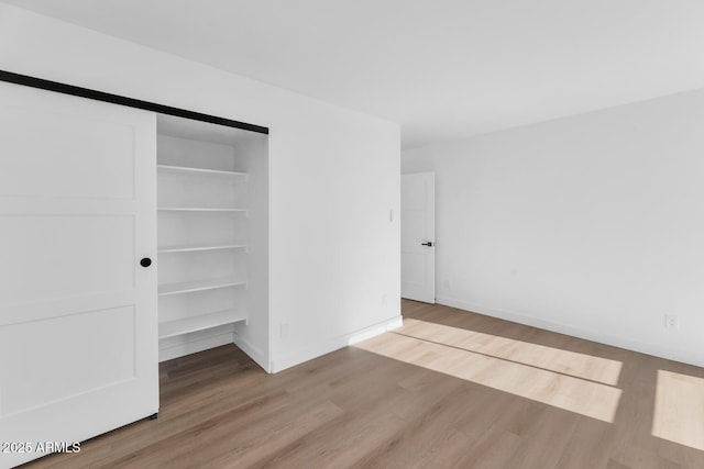 unfurnished bedroom featuring light wood-type flooring and a closet