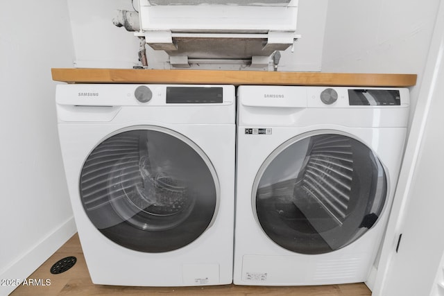 laundry room featuring hardwood / wood-style flooring and washing machine and clothes dryer