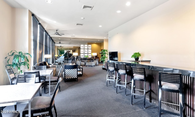 interior space featuring ceiling fan and dark colored carpet