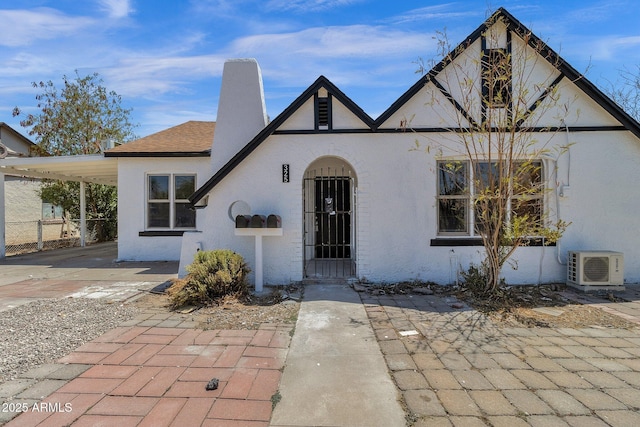 view of front of home with a carport and ac unit