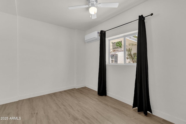 empty room with ceiling fan, light hardwood / wood-style floors, and a wall mounted AC