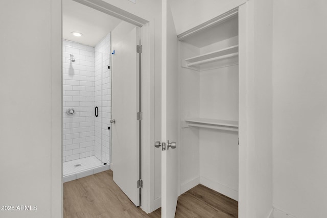 bathroom with hardwood / wood-style flooring and a shower with door