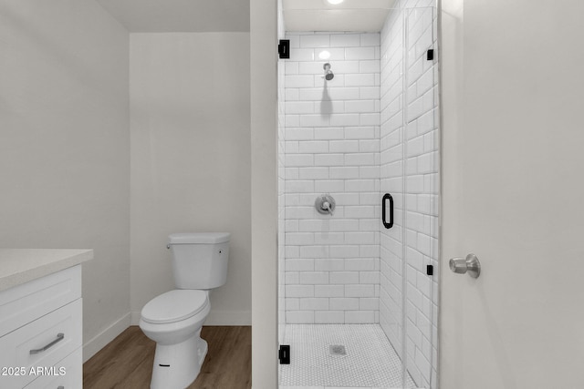 bathroom featuring a shower with door, vanity, wood-type flooring, and toilet