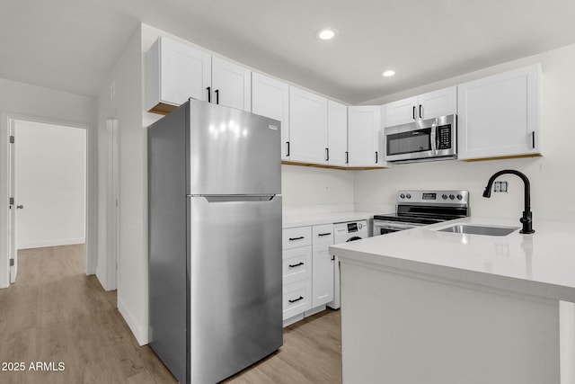 kitchen with light hardwood / wood-style floors, white cabinetry, and appliances with stainless steel finishes