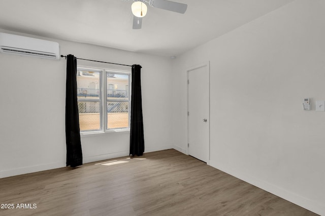 empty room featuring light wood-type flooring, an AC wall unit, plenty of natural light, and ceiling fan