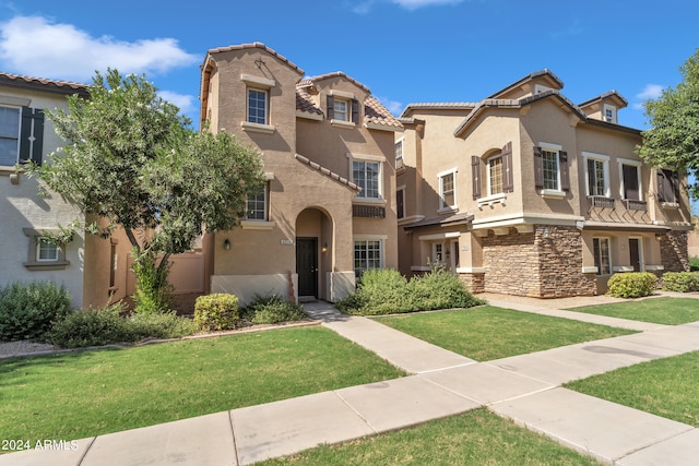 mediterranean / spanish-style house with a front yard