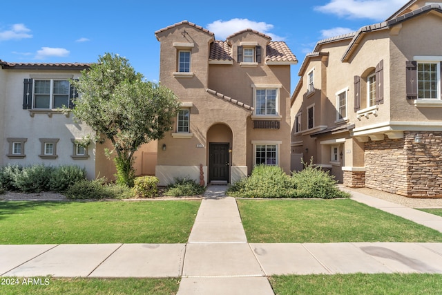 mediterranean / spanish-style house with a front yard