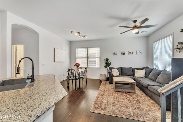 living room featuring ceiling fan, sink, and dark hardwood / wood-style flooring