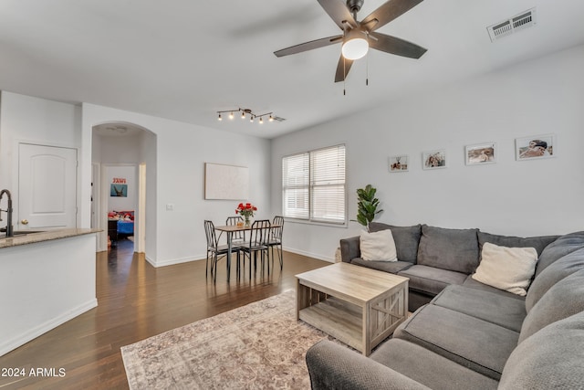 living room featuring dark hardwood / wood-style floors, sink, and ceiling fan