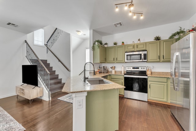 kitchen featuring sink, kitchen peninsula, green cabinetry, dark wood-type flooring, and appliances with stainless steel finishes