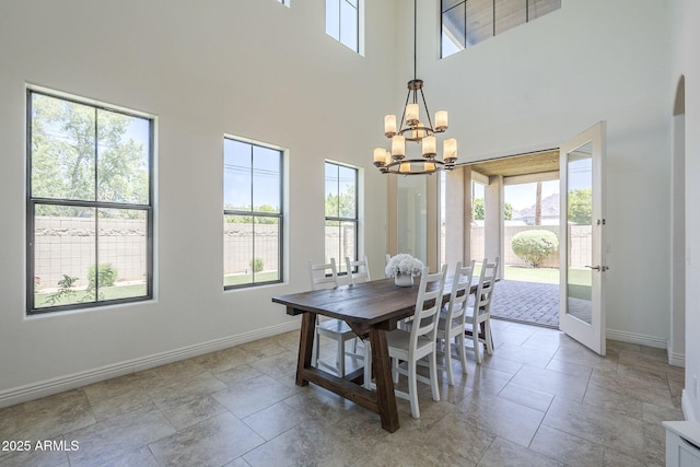3812 E Camelback Rd, Phoenix, AZ 85018 - dining room with a chandelier, baseboards, a towering ceiling, and stone tile flooring