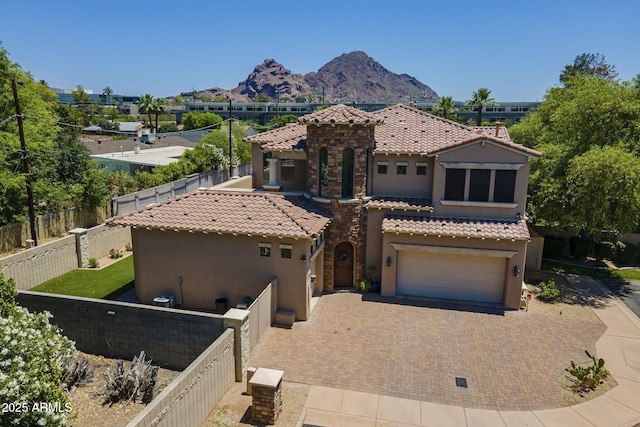 3812 E Camelback Rd, Phoenix, AZ 85018 - mediterranean / spanish house featuring stucco siding, a tiled roof, a garage, and a mountain view