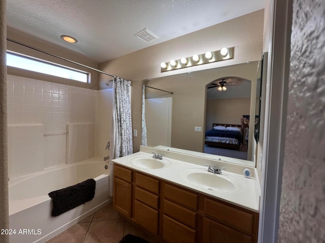 bathroom featuring vanity, shower / bath combo with shower curtain, ceiling fan, tile patterned floors, and a textured ceiling