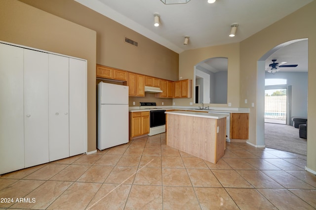 kitchen featuring freestanding refrigerator, under cabinet range hood, electric range oven, visible vents, and light countertops
