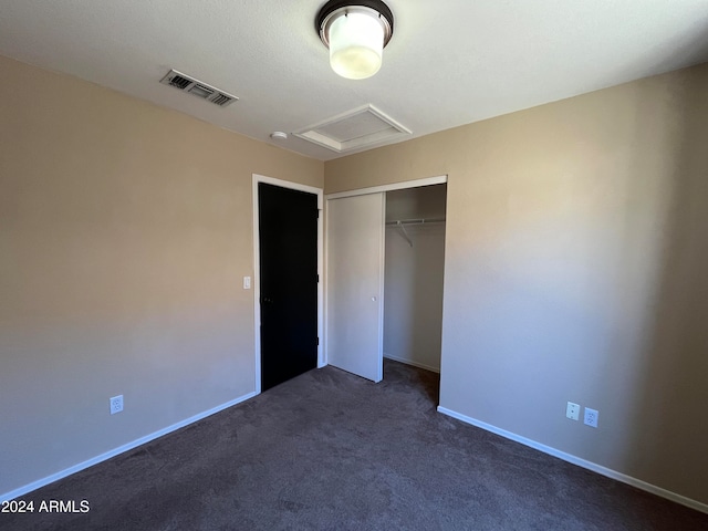 unfurnished bedroom featuring a closet and dark colored carpet