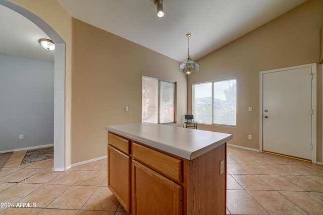 kitchen with vaulted ceiling, light tile patterned flooring, arched walkways, and light countertops