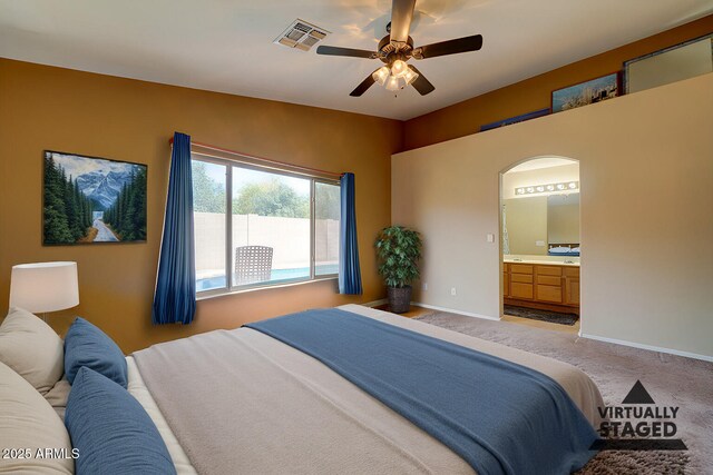 bedroom featuring light colored carpet, ensuite bath, baseboards, and visible vents