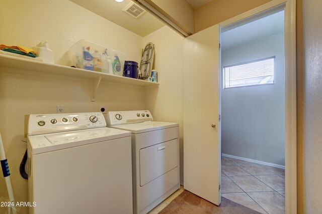 clothes washing area featuring laundry area, light tile patterned floors, visible vents, and washing machine and dryer