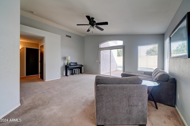 living room with ceiling fan, light carpet, and lofted ceiling