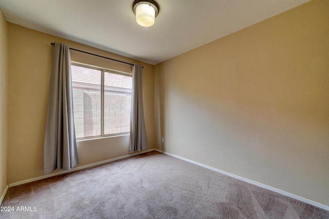 empty room featuring carpet and baseboards