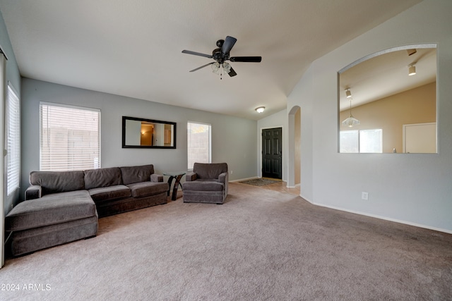 living room with lofted ceiling, ceiling fan, and carpet