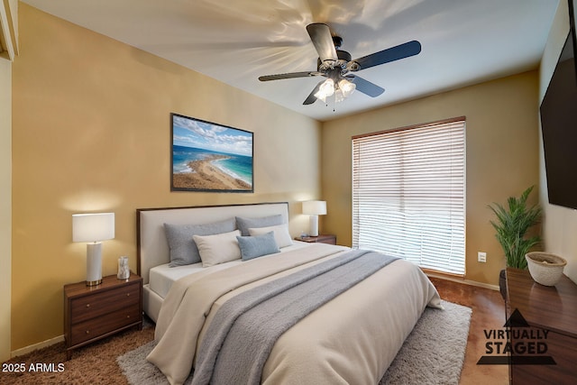carpeted bedroom with baseboards and ceiling fan