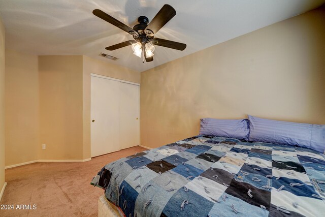 carpeted bedroom with baseboards, a ceiling fan, visible vents, and a closet