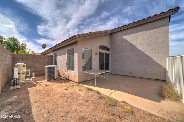 rear view of house featuring a fenced backyard, stucco siding, a tiled roof, and cooling unit