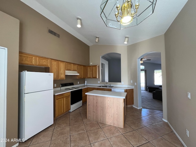 kitchen featuring white appliances, a center island, pendant lighting, sink, and ceiling fan with notable chandelier