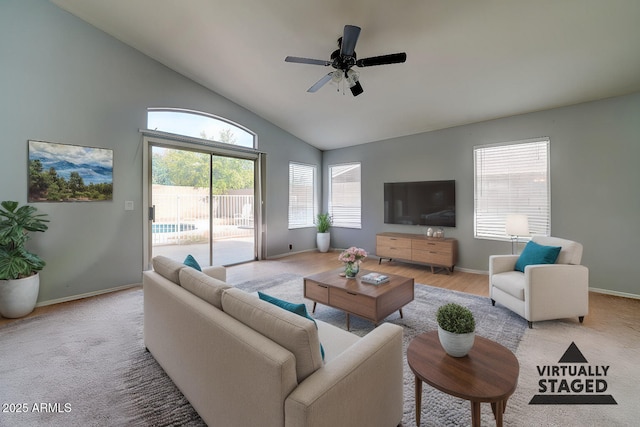 living room featuring baseboards, light carpet, lofted ceiling, and ceiling fan