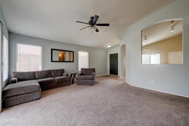 living room with carpet flooring, arched walkways, and plenty of natural light