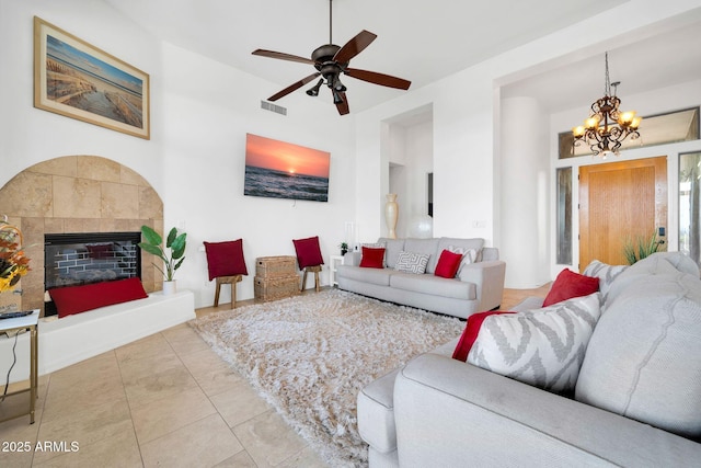 3335 W Carriage Dr, Phoenix, AZ 85086 - living area with ceiling fan with notable chandelier, a tiled fireplace, and visible vents