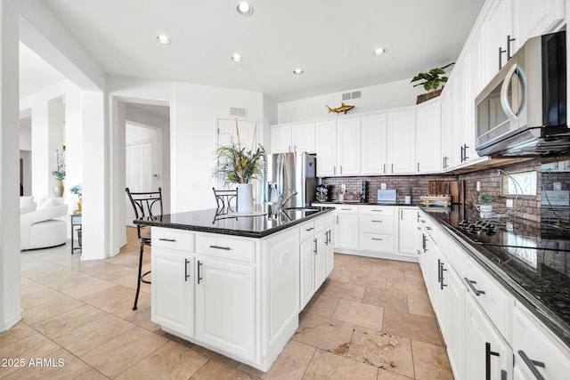 3335 W Carriage Dr, Phoenix, AZ 85086 - kitchen featuring tasteful backsplash, white cabinets, visible vents, stainless steel appliances, and a center island with sink