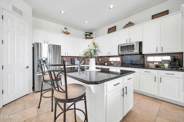 3335 W Carriage Dr, Phoenix, AZ 85086 - kitchen with visible vents, appliances with stainless steel finishes, white cabinetry, backsplash, and a kitchen island