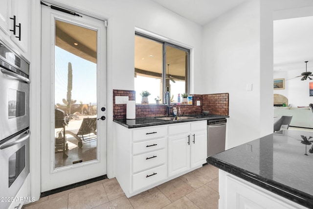 3335 W Carriage Dr, Phoenix, AZ 85086 - kitchen with tasteful backsplash, white cabinets, dark stone counters, stainless steel appliances, and a sink