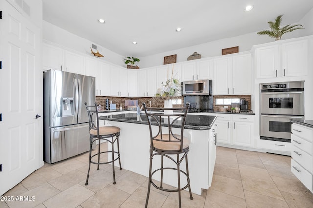 3335 W Carriage Dr, Phoenix, AZ 85086 - kitchen featuring white cabinets, backsplash, a center island, and appliances with stainless steel finishes