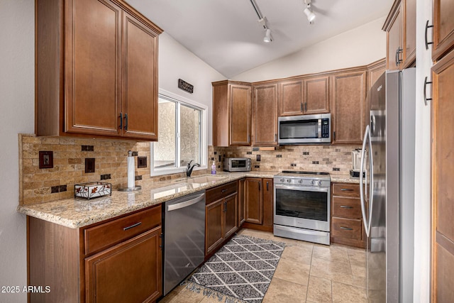 14819 W Lupine Ln, Surprise, AZ 85374 - kitchen with stainless steel appliances, a sink, vaulted ceiling, tasteful backsplash, and light stone countertops
