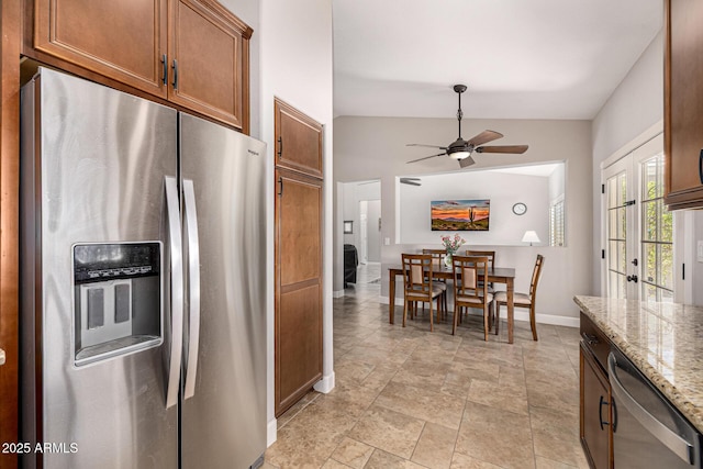 14819 W Lupine Ln, Surprise, AZ 85374 - kitchen featuring appliances with stainless steel finishes, a ceiling fan, baseboards, vaulted ceiling, and brown cabinets