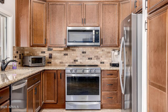 14819 W Lupine Ln, Surprise, AZ 85374 - kitchen with stainless steel appliances, a sink, and brown cabinets