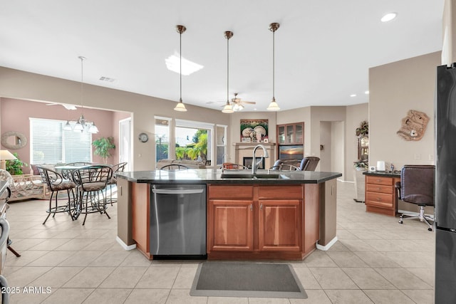 kitchen with sink, dishwasher, hanging light fixtures, and light tile patterned floors