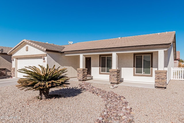 ranch-style house featuring covered porch and a garage