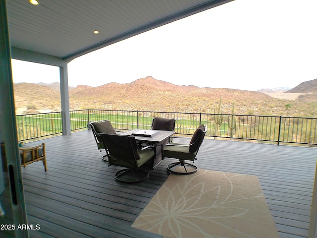 wooden terrace featuring outdoor dining space and a mountain view